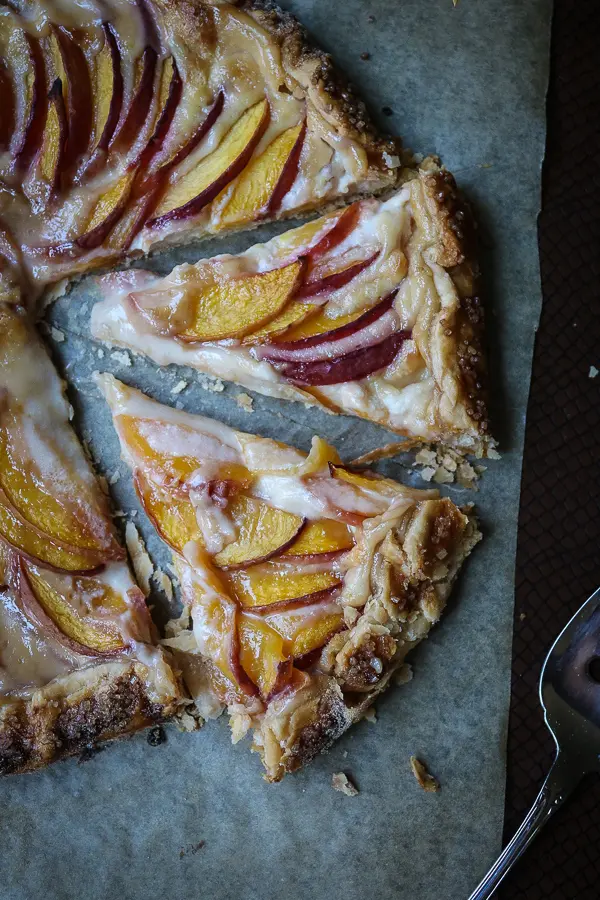 What happens when you combine the sweetness of summer peaches and the creaminess of a cream cheese icing and your favorite pie crust? You get a beautiful crostata dessert! Or this Peaches and Cream Crostata to be precise.