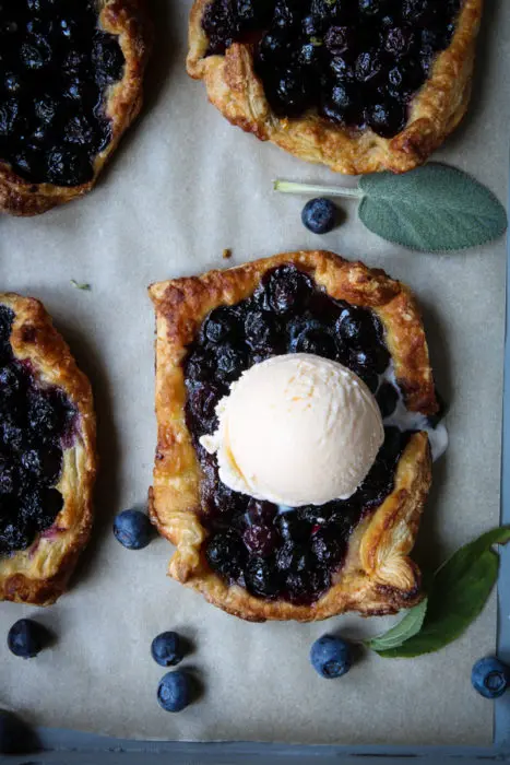 Mini blueberry tarts with scoop of vanilla ice cream.