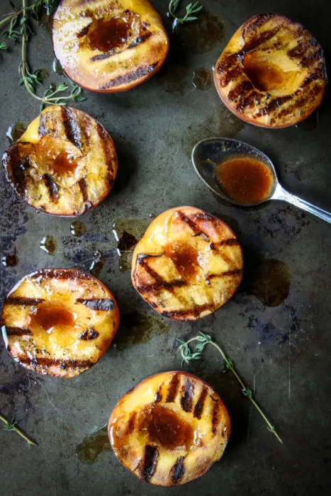 Grilled peaches with spoonful of buttery cinnamon honey drizzle