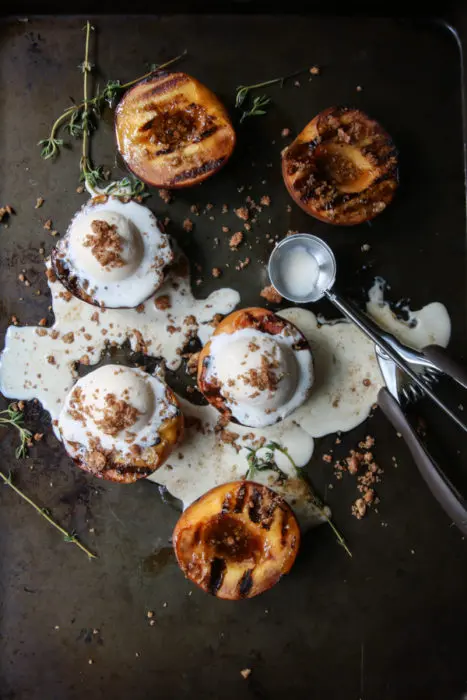 Plate of grilled peaches with melted ice cream